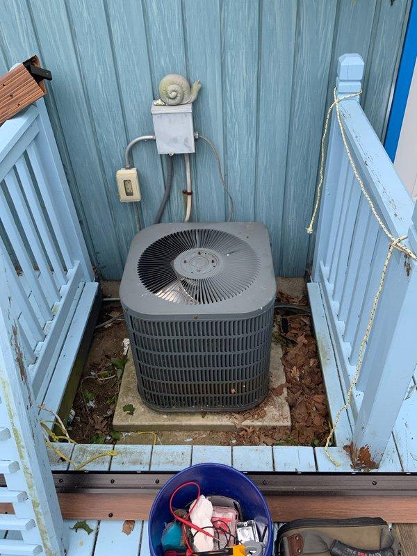 # HVAC Service Report

Responded to no cooling complaint on 10+ year old Goodman air conditioning system. Customer reported unit blowing air but not producing cold air and suspected low refrigerant charge. Upon arrival, performed comprehensive system diagnostic on outdoor condenser unit and indoor air handler/furnace combination.

Conducted visual inspection of outdoor condensing unit located in narrow side yard service area. Checked electrical disconnect, verified power supply, and inspected condenser coil condition. Unit showed age-related wear consistent with 10+ year old equipment. Examined indoor air handler components in basement utility area, including evaporator coil access, refrigerant line connections, and airflow pathways.

Performed refrigerant pressure testing on both high and low side service ports to determine system charge level. Confirmed refrigerant deficiency indicated by abnormal pressure readings and lack of cooling capacity. Conducted leak detection procedures usi