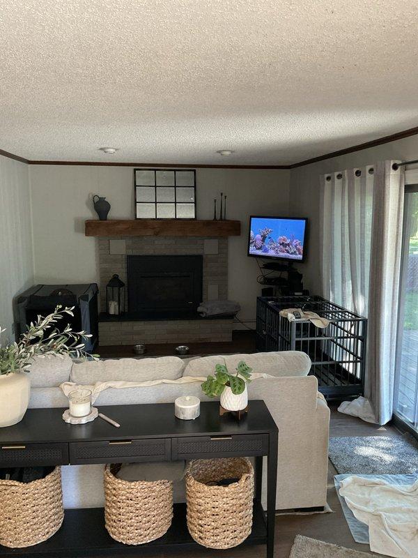 Completed on-site assessment for mini-split heat pump installation in residential property. Evaluated two interior locations including living room with stone fireplace and adjacent room with through-wall AC unit to determine optimal placement for 10,000-12,000 BTU ductless mini-split system. Documented existing HVAC conditions, wall construction, electrical access points, and recommended indoor head unit mounting locations with consideration for airflow distribution and aesthetic integration with current décor.