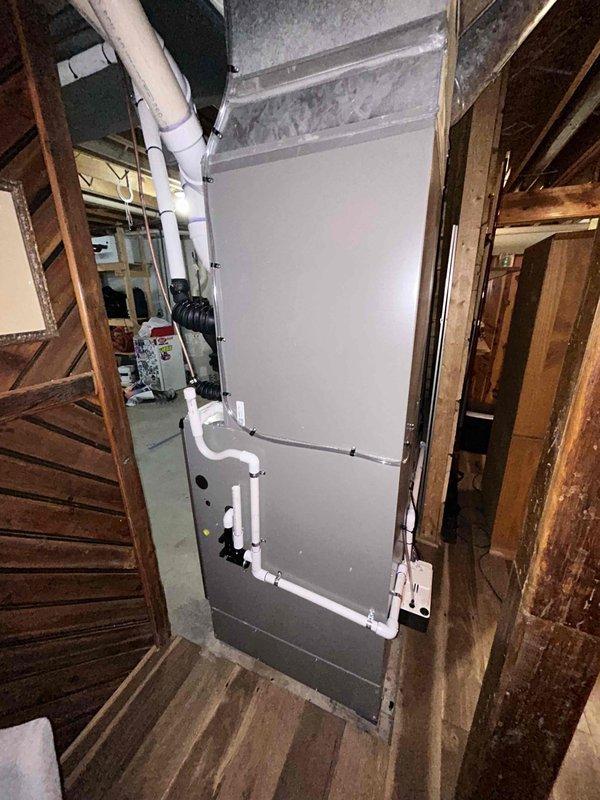 Completed full HVAC system installation in mechanical space, including 110,000 BTU furnace, whole-home humidifier, and 4-ton air conditioning unit with rear discharge configuration. Installed new air handler unit between structural framing with proper mounting and leveling, routed PVC condensate drainage lines along equipment, and connected flexible metal conduit for electrical service to wall-mounted disconnect switch. Reconnected all electrical components per code requirements, secured wiring with appropriate clips and supports, and installed flexible ductwork connections to existing duct system.