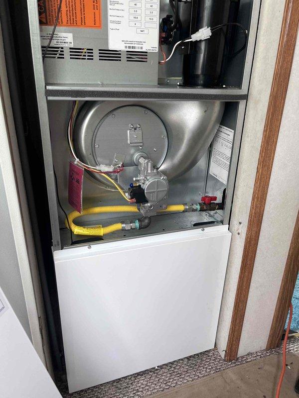 Completed replacement of manufactured home furnace with new 70,000 BTU unit. Installation included all mechanical and electrical connections, gas line hookup with flexible yellow corrugated connector, and thermostat programming. New furnace features control board, blower motor assembly, gas valve, and all safety components properly installed and tested. Unit commissioned and verified operational with thermostat set to 75°F.