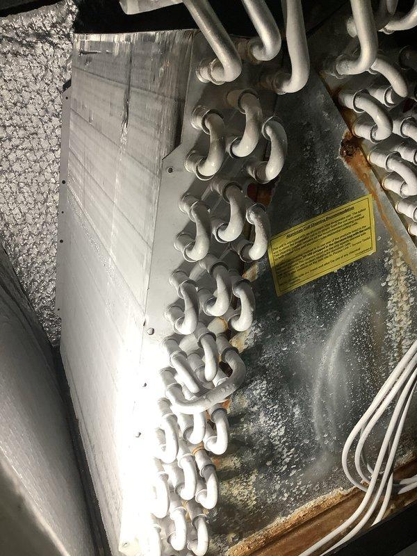 Performed routine maintenance inspection on residential HVAC system as part of Club AC and Heat agreement. Upon arrival, measured electrical amperage at outdoor unit disconnect showing 123.9 amps. Interior inspection revealed significant ice buildup on evaporator coil assembly and surrounding components, indicating restricted airflow or possible refrigerant issue. Observed corrosion and rust staining at base of coil assembly suggesting previous moisture accumulation. Documented equipment condition with photos for service records. System requires follow-up diagnostic service to address icing condition and restore proper operation.