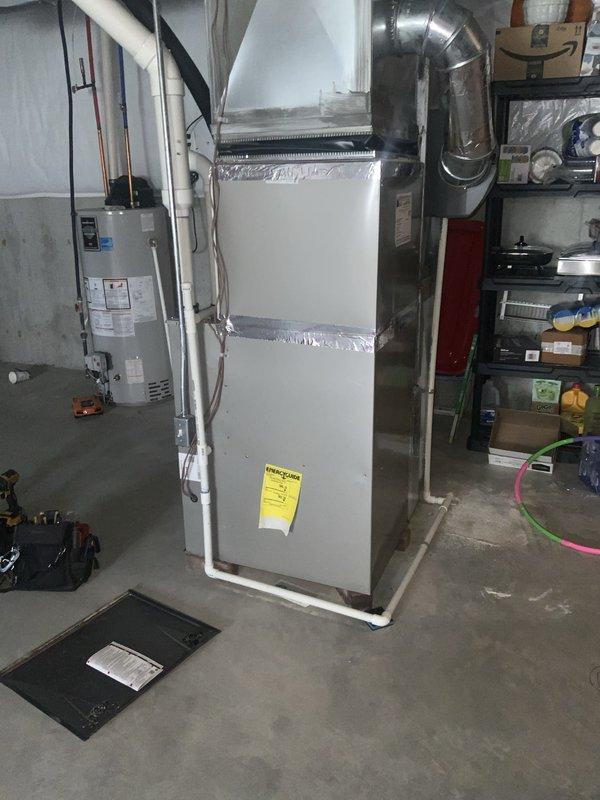 Completed routine summer maintenance and AC tune-up on a 4-year-old air conditioning system per membership agreement. Inspected blower wheel assembly and found dust accumulation on squirrel cage blower fins, which is typical for a system of this age; assessed overall blower functionality and condition as satisfactory. Performed standard maintenance procedures on furnace and AC system located in basement mechanical room, verified proper operation of all components, and documented equipment condition with photos showing blower assembly and main HVAC unit with connected ductwork.