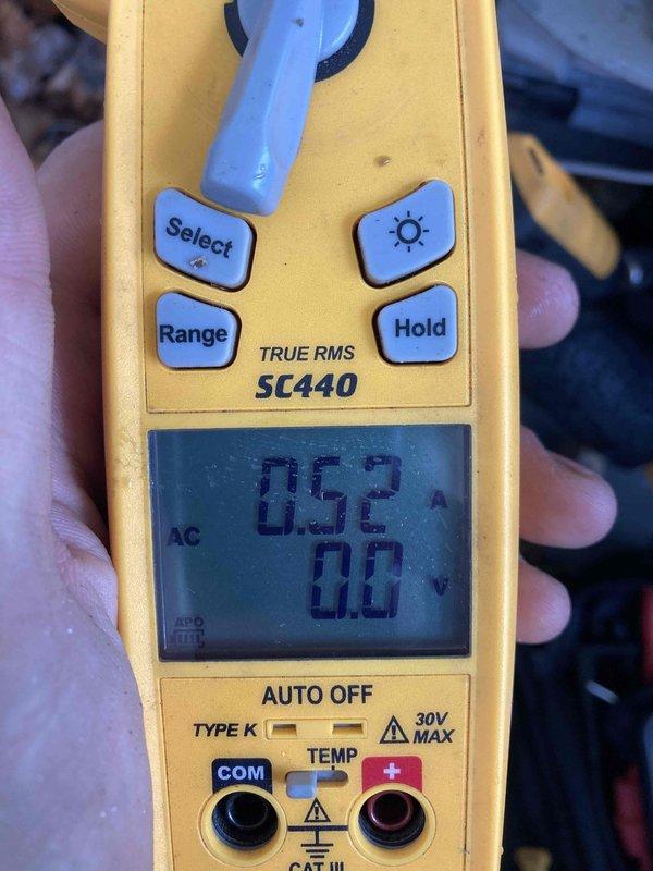 Performed routine maintenance inspection on air conditioning system as part of club preventative maintenance agreement. Utilized digital multimeter to verify electrical measurements, recording 20.5 amp inrush current and 0.52 amp operating current with proper voltage readings, confirming compressor and system components operating within normal parameters.