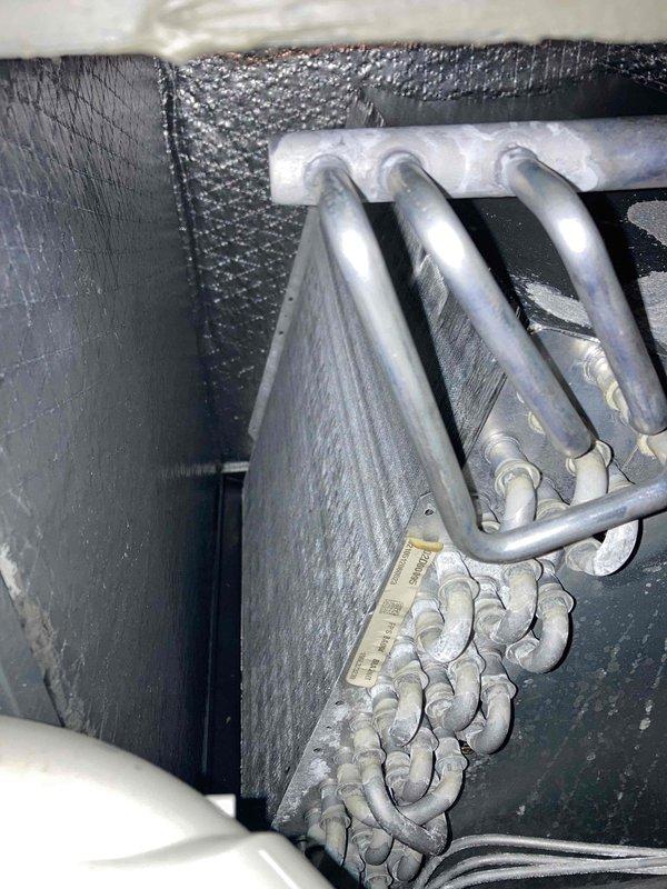 Completed routine maintenance inspection under Club AC12-4 agreement. Upon arrival, performed electrical diagnostics on the indoor air handler unit using digital multimeter, measuring voltage at control board terminals which read 485.1 volts. During inspection, discovered significant ice buildup on refrigerant lines and evaporator coil. The heavy frost accumulation covering the suction line and coil surfaces indicates a system malfunction, likely caused by restricted airflow, low refrigerant charge, or faulty metering device. Documented conditions with photos showing the extent of ice formation on the copper tubing and unit components. This freeze-up condition requires immediate attention as continued operation could damage the compressor and reduce system efficiency.