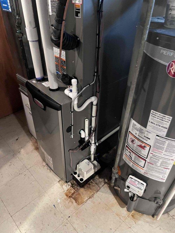 Responded to callback for air conditioning system not turning on with thermostat set at 70°F and house temperature at 72°F with no airflow from vents. Upon arrival, inspected HVAC system installation in utility room including furnace unit, condensate pump, and associated piping. Verified all equipment connections, electrical supply, and thermostat wiring. System operational after troubleshooting and resolving issue preventing AC compressor engagement.