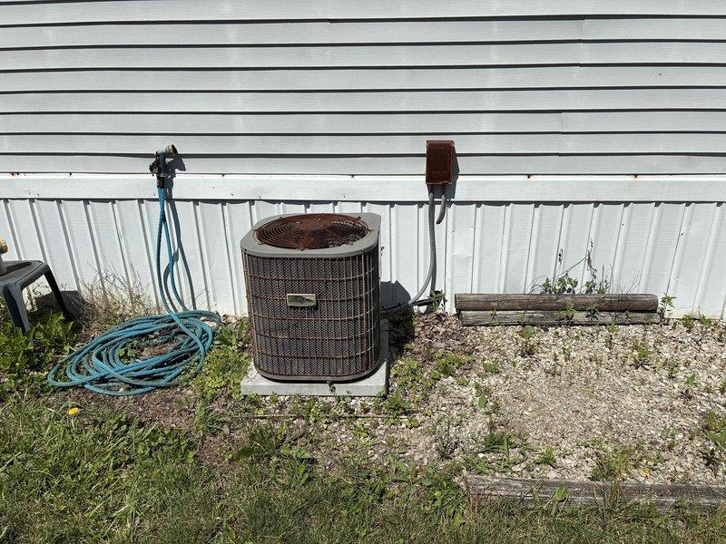 Performed comprehensive assessment of non-functional residential air conditioning system. Evaluated aging outdoor condenser unit showing significant weathering, rust, and corrosion on exterior surfaces, indicating end of serviceable life. Inspected interior components including air return grille and ductwork connections within wall cavity. Documented equipment condition through photography and provided replacement estimate for complete AC system upgrade to restore cooling functionality.