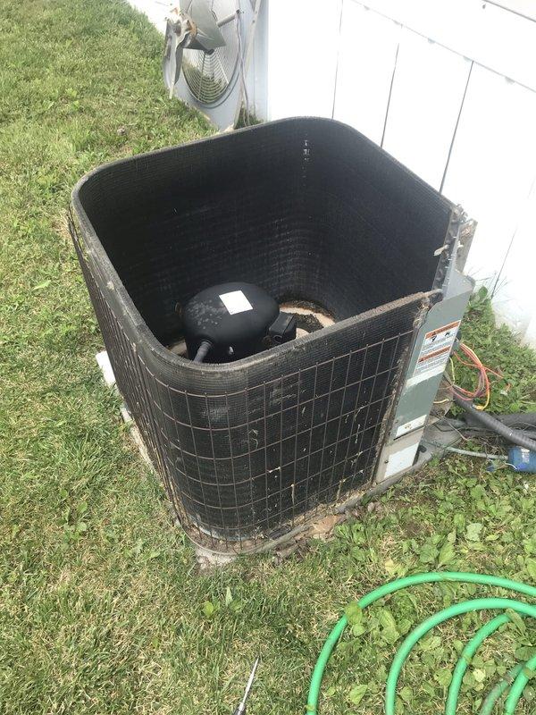 Responded to no-cooling emergency call on 20-year-old AC system that tripped breaker and produced smoke from outdoor unit the previous evening. Upon arrival, found outdoor condenser unit with significant debris accumulation, deteriorated wiring connections, and evidence of electrical failure in compartment. Inspected electrical components and wiring harness, which showed severe weathering, contamination, and heat damage consistent with reported smoking incident. Documented compromised condition of unit including rust, organic debris buildup around electrical connections, and overall lack of maintenance contributing to system failure. Due to age of equipment and extent of damage to electrical components, recommended system replacement rather than repair given safety concerns and cost-effectiveness for 20-year-old unit operating beyond typical lifespan.