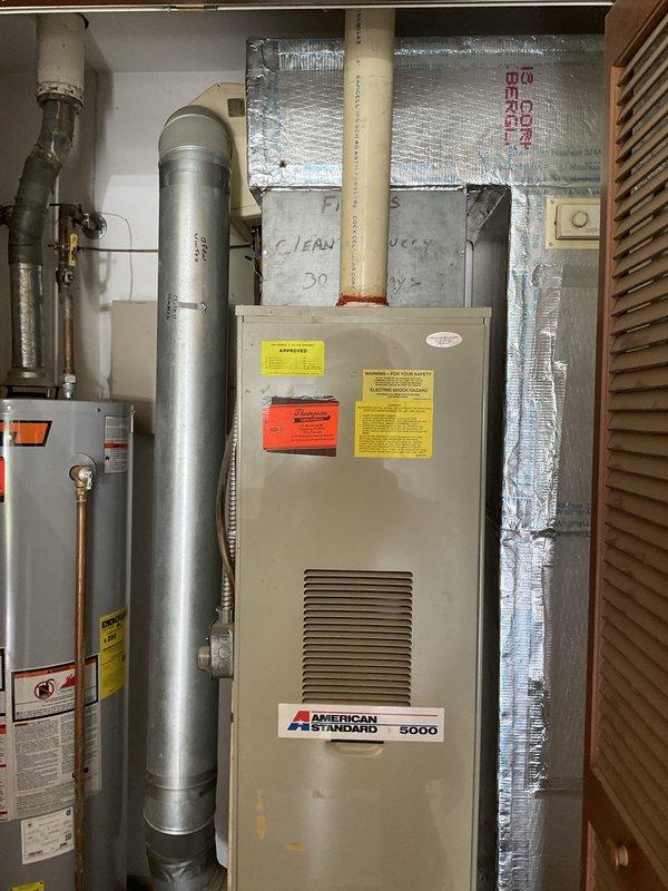 Conducted comprehensive evaluation of 35-year-old HVAC system following non-operational air conditioning complaint and prior replacement recommendation from another contractor. Inspected existing American Standard Model 5000 furnace located in basement mechanical room and outdoor air conditioning unit to assess overall system condition, efficiency, and remaining service life. Documented current equipment configuration including ductwork connections, refrigerant lines, electrical components, and ventilation systems. Photographed furnace installation, surrounding mechanical components, and utility room layout to support replacement proposal. Provided detailed estimate for complete HVAC system replacement including new furnace and air conditioner to address aging equipment concerns and restore reliable climate control functionality.