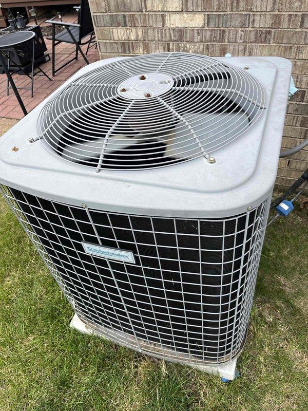 Completed comprehensive air conditioning tune-up on outdoor condensing unit. Performed standard maintenance inspection, verified proper operation of fan motor and compressor, cleaned debris from exterior surfaces, and documented equipment condition with service photos showing unit positioned on grass pad with adequate clearance for airflow.