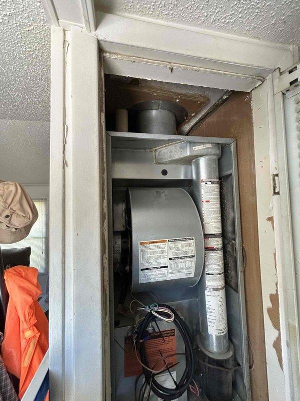 Completed installation of 2.5 ton air conditioning system with matching evaporator coil in closet-mounted configuration. Unit was installed in white-framed compartment with rear discharge orientation, electrical connections established, refrigerant lines connected to outdoor condenser, and system evacuated to proper vacuum levels as verified by digital vacuum gauge reading. System tested and confirmed operational upon completion.