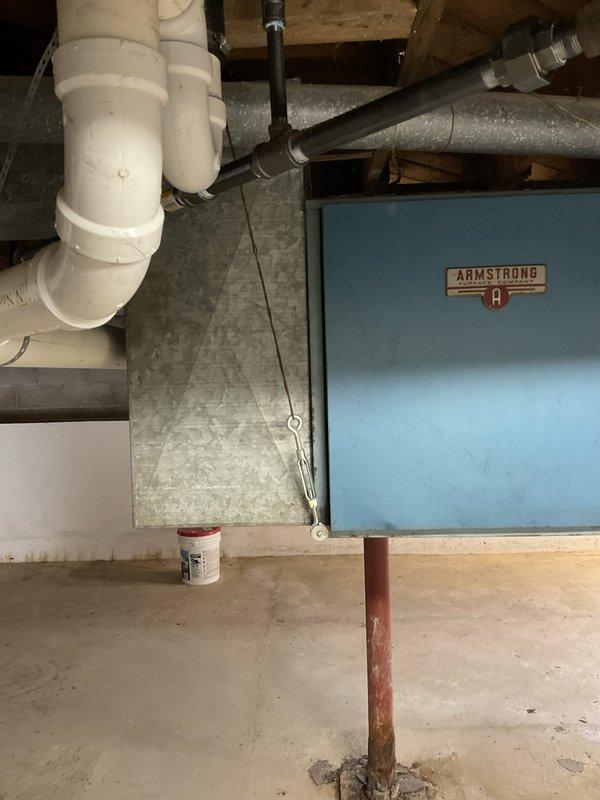 Conducted site evaluation of existing Armstrong air conditioning system located in Michigan basement to provide replacement estimate. Current unit is older model but operational at time of inspection. Assessed existing air handler configuration, ductwork connections, drainage system with PVC piping, and electrical supply routing. Documented equipment placement constraints in unfinished basement area with exposed joists, concrete flooring, and support columns. Evaluated clearance requirements and access considerations for future replacement installation. Provided comprehensive estimate for new AC system replacement compatible with natural gas furnace and existing duct infrastructure.