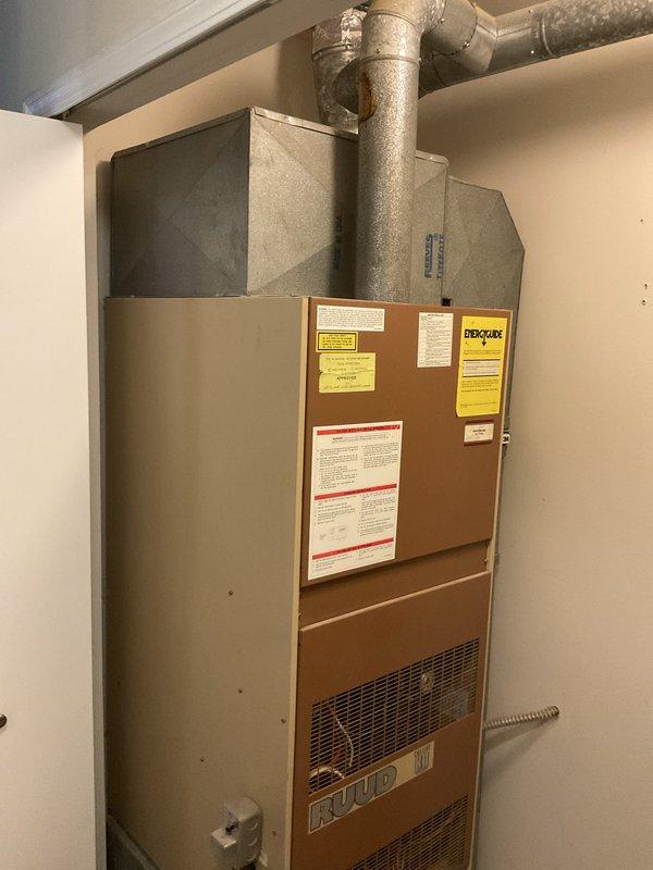 Conducted comprehensive assessment of existing Ruud natural gas furnace located in utility closet for replacement estimate. Unit confirmed operational but identified as very old system requiring replacement evaluation. Documented current installation configuration including ductwork connections, gas line routing, condensate piping, and equipment placement within confined mechanical room space for accurate replacement system sizing and specifications.