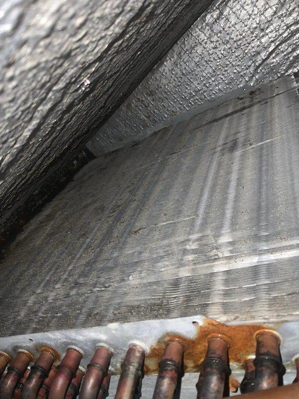 Completed preventative maintenance agreement visit for Club AC10-2 service on residential air conditioning and system inspection. Upon inspection, discovered significant frost and ice accumulation on refrigerant lines in attic space, indicating potential low refrigerant charge or restricted airflow issues requiring further diagnostic evaluation. Documented exterior condensing unit condition showing advanced corrosion on copper refrigerant piping and deteriorated wooden equipment platform requiring attention to prevent future equipment damage and ensure proper system operation.