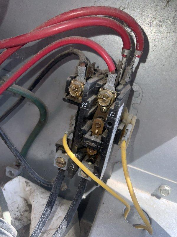 # No Cooling - 20 Year Old Central AC System

Responded to no cooling call on residential central air conditioning system approximately 20 years old. Upon arrival, confirmed entire home was without cooling. Accessed outdoor condensing unit and removed service panel to inspect electrical and mechanical components.

Performed visual inspection of contactor, capacitor, and wiring connections. Found aged wiring with accumulated dirt and weathering consistent with unit age. Checked electrical connections at contactor terminals, noting multiple red power wires, ground wire, and control wiring. Inspected dual run capacitor mounted in outdoor unit compartment.

Conducted diagnostic testing to determine root cause of no cooling condition. Evaluated compressor operation, contactor function, and capacitor performance. Assessed refrigerant system for potential leaks or charge issues as requested.

Given the advanced age of the equipment at 20 years old, discussed system condition and repair versus