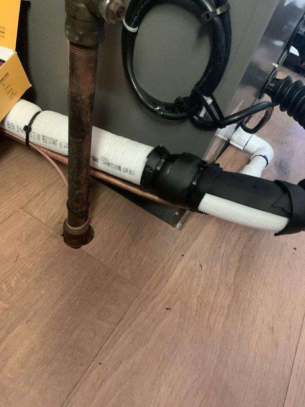 # HVAC Install Callback - Condensate Leak Repair

Responded to callback for condensate leak at indoor air handler unit. Upon arrival, confirmed active leak at evaporator coil drain connection causing water to drip onto floor beneath unit. Inspected drain line assembly and identified inadequate sealing at coil drain pan connection point.

Addressed leak by properly sealing coil drain connection using foam tape to ensure watertight seal. Replaced deteriorated lineset insulation that had allowed condensation formation on refrigerant lines. Secured all insulation and drain line components with black zip ties to prevent future displacement or separation. Verified drain line slope and verified proper condensate flow through PVC drain assembly to floor drain.

Tested system operation through complete cooling cycle. Monitored drain pan and connection points for 20 minutes while unit ran to confirm no further leakage. All connections remained dry with no evidence of water escaping system. Clean