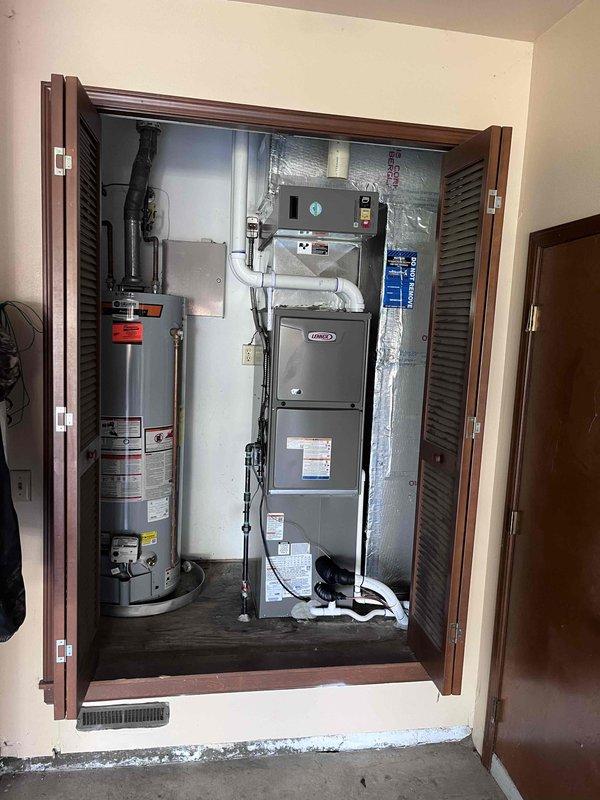 Completed full HVAC system installation consisting of a 70,000 BTU Lennox gas furnace and 2.5 ton air conditioning unit positioned on the right side of the property. The furnace was installed in an interior utility closet with proper venting and ductwork connections, while the outdoor condensing unit was positioned on a pad adjacent to the brick foundation with refrigerant lines, electrical connections, and condensate drainage properly installed and tested. All equipment was commissioned, system performance verified, and the installation brought to full operational status per manufacturer specifications.