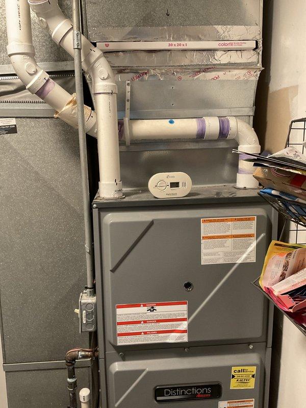 Performed estimate visit for HVAC system replacement. Documented existing outdoor air conditioning condenser unit mounted on concrete pad with visible weathering and dirt accumulation, along with electrical disconnect boxes and conduit connections. Assessed indoor Distinctions brand furnace installation in utility area with associated PVC venting, ductwork, and filter housing. Photographed both outdoor and indoor equipment to provide comprehensive system evaluation for replacement proposal.