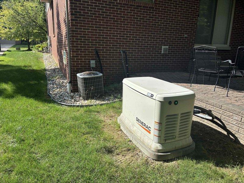Conducted on-site evaluation for HVAC system replacement at residential property. Assessed existing 4-6 ton air conditioning unit located on exterior pad with decorative rock bed, confirmed unit operational with electrical service functioning properly. Documented current equipment configuration, installation location, electrical connections, and surrounding utility infrastructure including gas meter and electrical panel for replacement specifications and permitting requirements.
