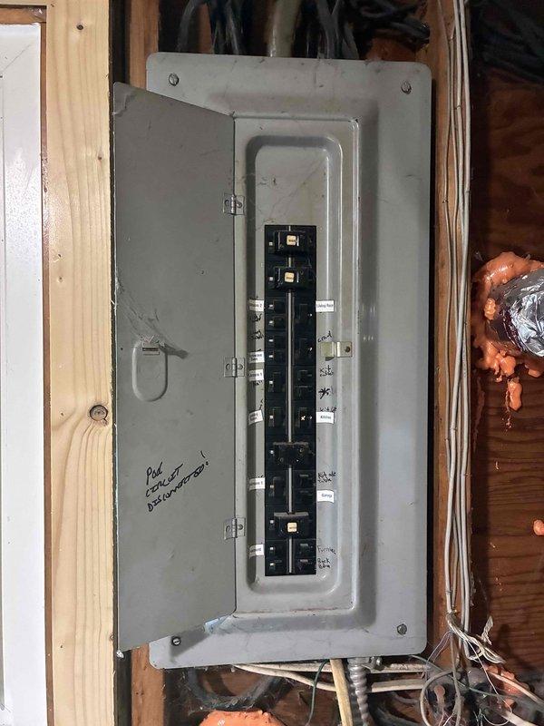 Conducted on-site assessment of non-operational air conditioning system with functional furnace in aging 2-4 ton HVAC installation. Evaluated existing equipment condition, electrical panel configuration with exposed circuit breakers, and mechanical space constraints within unfinished utility area featuring exposed framing and infrastructure. Documented current system layout including air handler unit, PVC drainage/vent lines, copper refrigerant piping, and electrical connections to support comprehensive replacement estimate for complete AC system upgrade.