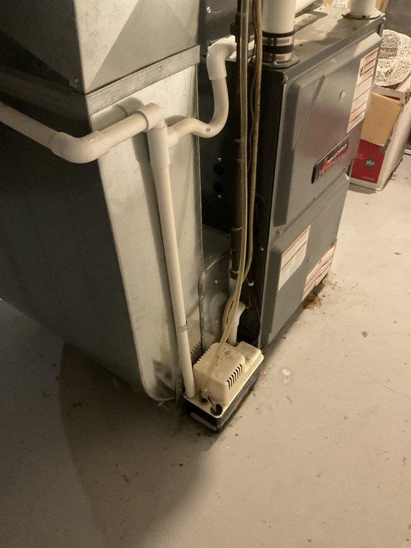 Conducted comprehensive assessment of non-operational air conditioning system and aging HVAC equipment located in basement utility area. Evaluated existing furnace, air handler, and associated ductwork and drainage systems to provide equipment replacement estimate. Documented current installation configuration including PVC venting, copper refrigerant lines, and electrical connections to determine proper sizing and specifications for new system components.
