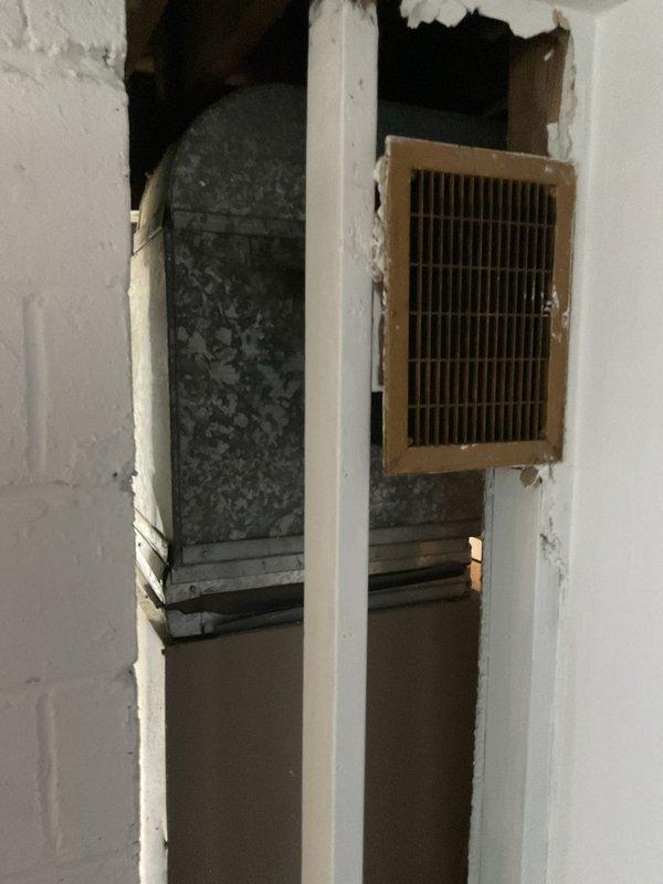Conducted replacement consultation for 30+ year old residential air conditioning system that had ceased operation. Evaluated existing outdoor condensing unit and interior ductwork distribution system, documenting current equipment condition and installation configuration. Assessed vertical chase containing supply ductwork and register locations, noting flexible duct connections and wall-mounted supply vents. Photographed existing HVAC infrastructure including air distribution pathways and interior ductwork access points to support replacement system design and equipment sizing recommendations. Provided homeowner with comprehensive options for complete system replacement to restore whole-home cooling capacity.