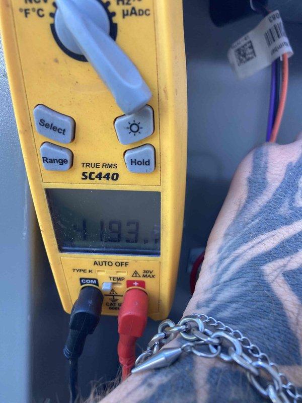 Responded to no cooling call for club AC unit. Upon arrival, performed diagnostic inspection of system components including evaporator coil and electrical connections. Measured voltage at capacitor terminals using digital multimeter, recording 11.99 volts. Inspected refrigerant lines, mounting hardware, and heat exchanger assembly. Documented equipment condition with photos for maintenance records.