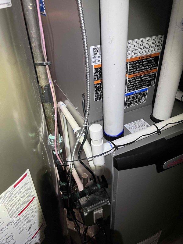 Completed full HVAC system installation including a 70,000 BTU furnace and 2-ton air conditioning unit in utility closet. Performed all mechanical and electrical connections, installed PVC condensate drainage system with proper pitch and routing, ran refrigerant lines with appropriate insulation, and reconnected all existing ductwork. Installed flexible metal conduit for electrical wiring, secured all components per code requirements, applied manufacturer specification labels and service information placards, and verified proper operation of complete system upon startup.