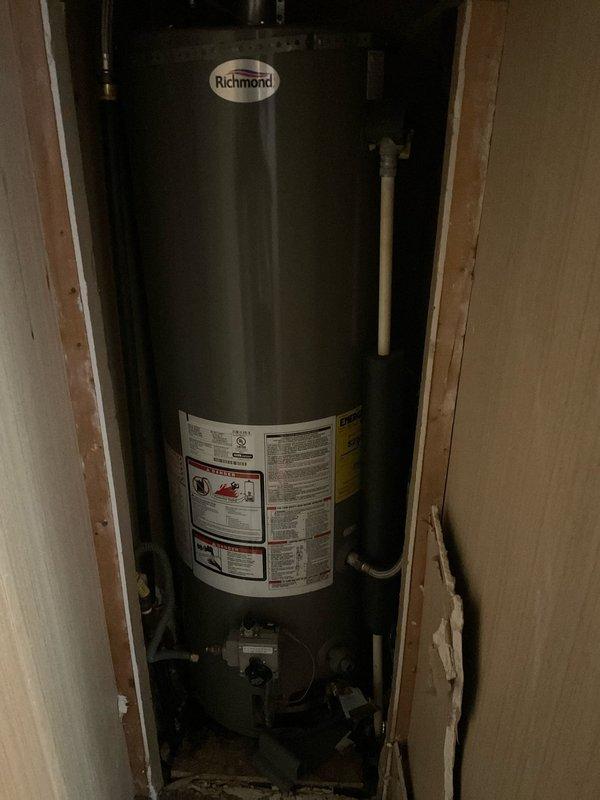 Conducted plumbing estimate for replacement of existing Richmond brand 30-gallon standard water heater in mobile home. Inspected current working unit installed in recessed wall cavity with natural draft venting, assessed existing plumbing connections including copper supply lines and flexible tubing, and evaluated installation space between wall studs to provide replacement specifications and recommendations.