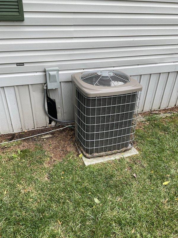 Conducted on-site evaluation of existing air conditioning system for replacement estimate. Current unit is operational but of undetermined older age, located exterior to residence with natural gas furnace inside. Assessed electrical service panel, outdoor condenser unit positioning on concrete pad, disconnect box configuration, and existing refrigerant line routing to provide comprehensive replacement system recommendations.