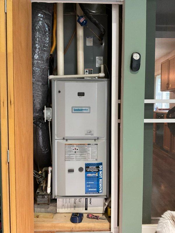 Conducted comprehensive site assessment for air conditioning replacement at residential property. Evaluated existing HVAC system configuration featuring ComfortMaker furnace installed in interior utility closet with associated ductwork and components. Documented current equipment specifications, installation layout, and utility connections including gas meter location on exterior wall. Photographed indoor furnace unit, duct configuration, and outdoor AC unit positioning to prepare detailed equipment replacement estimate. Assessed access points, electrical service availability, and clearance requirements for new air conditioning system installation.