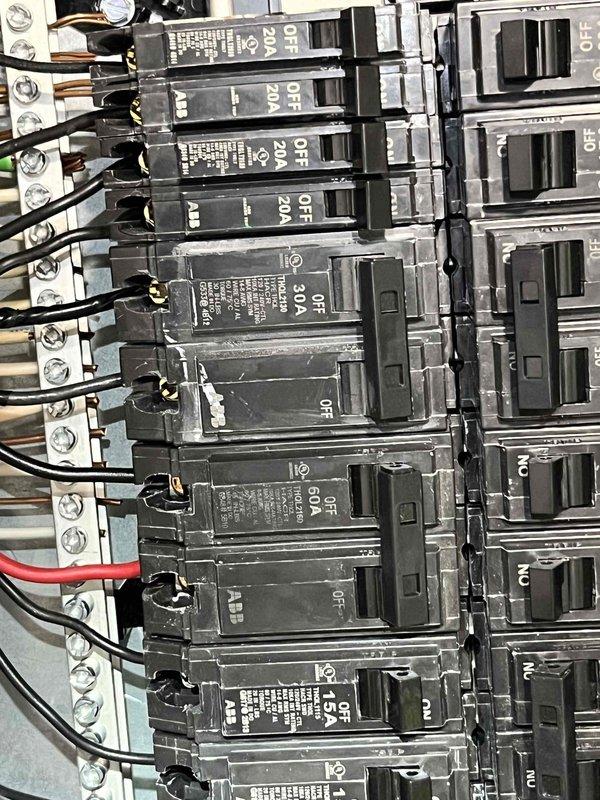 Responded to no-cooling call on residential air conditioning system less than 10 years old. Upon arrival, verified unit was blowing warm air with no cooling capacity. Performed diagnostic inspection of electrical system and documented electrical panel condition showing proper circuit breaker configuration and connections for HVAC equipment.