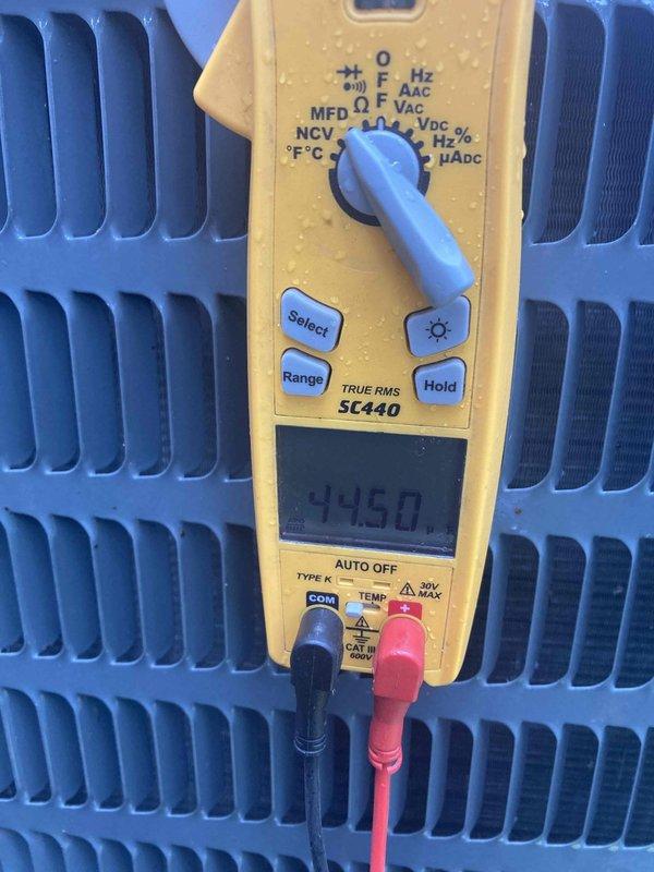# HVAC Service Report

Responded to no cooling complaint on air conditioning system. Upon arrival, performed diagnostic testing of the outdoor condensing unit. Utilized digital multimeter to measure electrical parameters and temperature readings across the condenser coil. Display readings indicated temperature differential of 44.5 degrees, suggesting potential refrigerant flow or heat exchange issues. Inspected condenser coil fins for proper airflow and system operation. Documented equipment conditions with diagnostic measurements for service records.