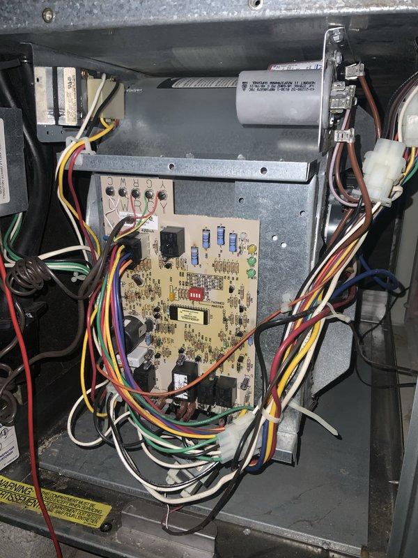 Responded to no cooling call on 20-year-old central air conditioning system. Upon inspection, found blower motor assembly with signs of wear and control board with multiple wire connections to capacitor and electronic components. Documented system conditions with photos of blower wheel assembly and main control board for diagnostic purposes.