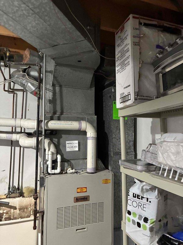 Conducted comprehensive assessment of existing Arcoaire furnace system and electrical infrastructure for HVAC replacement estimate. Documented current equipment configuration including furnace unit, electrical panel with arc fault circuit breakers, PVC ventilation piping, metal ductwork, and associated mechanical components in basement utility area. Evaluated system accessibility, existing electrical service capacity, and spatial constraints for replacement equipment installation planning.