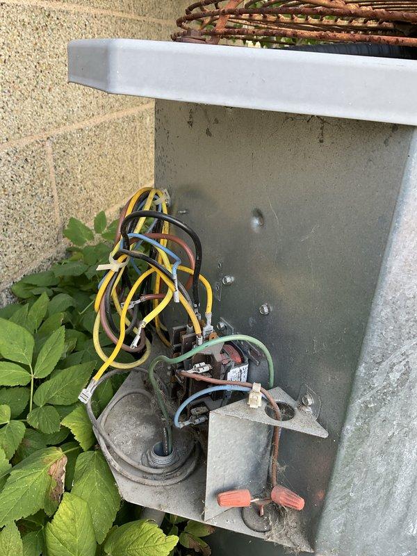 Responded to service call for non-operational AC fan. Upon arrival, inspected outdoor condensing unit electrical components and discovered severely corroded and aged disconnect box with deteriorated fuses and oxidized connections. Found left fuse holder contained worn cylindrical fuse showing significant corrosion on copper components, while right fuse holder had blue cylindrical fuse. Terminal block connections displayed weathering and oxidation consistent with extended outdoor exposure. Multiple wire connections with orange wire caps showed signs of age and environmental degradation. Replaced failed fuses, cleaned corroded terminals, and verified all electrical connections were secure. Tested unit operation and confirmed AC fan motor now functions properly. Recommended monitoring system performance and considering disconnect box replacement due to advanced corrosion of enclosure components.