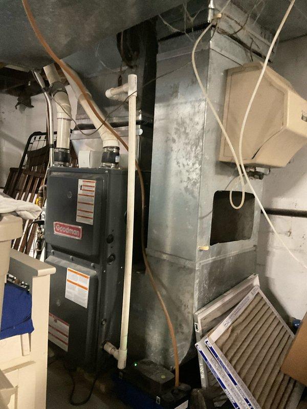 Completed comprehensive site evaluation for complete HVAC system replacement. Documented existing Goodman furnace installation in basement mechanical room along with current ductwork configuration, and assessed outdoor condensing unit positioned against building exterior with electrical disconnect and conduit routing. Provided detailed replacement quote covering both indoor and outdoor equipment components.
