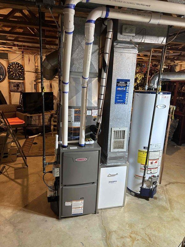 Completed full HVAC system installation including a 70,000 BTU furnace and 2-ton air conditioning unit positioned in the rear yard. Installed humidifier unit integrated with the furnace system and reconnected all necessary utilities. Mechanical installation included proper venting with white PVC piping secured to ceiling joists, ductwork connections, and exterior penetrations sealed with caulking at the foundation level. All equipment positioned in basement utility area with appropriate clearances maintained for service access and safe operation.