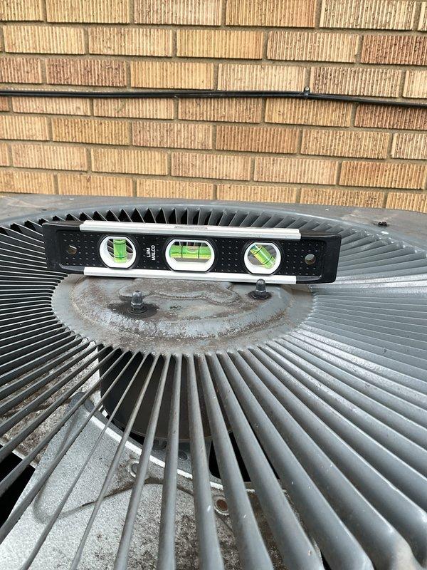 # HVAC Service Report - No Cooling Condition

Responded to no cooling complaint on residential air conditioning system over 10 years old. Upon arrival, verified outdoor condenser unit was not operating. Performed visual inspection of outdoor unit and found condenser fan motor failed to energize. Checked unit levelness as part of standard diagnostic protocol.

Removed access panel to inspect electrical components. Located dual run capacitor and contactor assembly mounted on interior control panel. Tested capacitor with multimeter and found readings within acceptable range. Verified contactor operation and found contacts engaging properly. Traced wiring from capacitor to condenser fan motor and compressor terminals. All wire connections appeared secure with no signs of burning or heat damage.

Further diagnosis revealed condenser fan motor had seized and would not rotate freely when manually tested. Motor windings tested showed open circuit, confirming motor failure. Compressor tested op