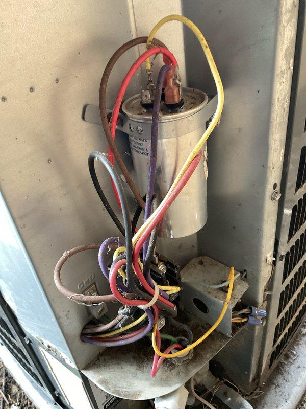 # HVAC Service Report - No Cooling Condition

Responded to no cooling complaint on residential air conditioning system over 10 years old. Upon arrival, verified outdoor condenser unit was not operating. Performed visual inspection of outdoor unit and found condenser fan motor failed to energize. Checked unit levelness as part of standard diagnostic protocol.

Removed access panel to inspect electrical components. Located dual run capacitor and contactor assembly mounted on interior control panel. Tested capacitor with multimeter and found readings within acceptable range. Verified contactor operation and found contacts engaging properly. Traced wiring from capacitor to condenser fan motor and compressor terminals. All wire connections appeared secure with no signs of burning or heat damage.

Further diagnosis revealed condenser fan motor had seized and would not rotate freely when manually tested. Motor windings tested showed open circuit, confirming motor failure. Compressor tested op