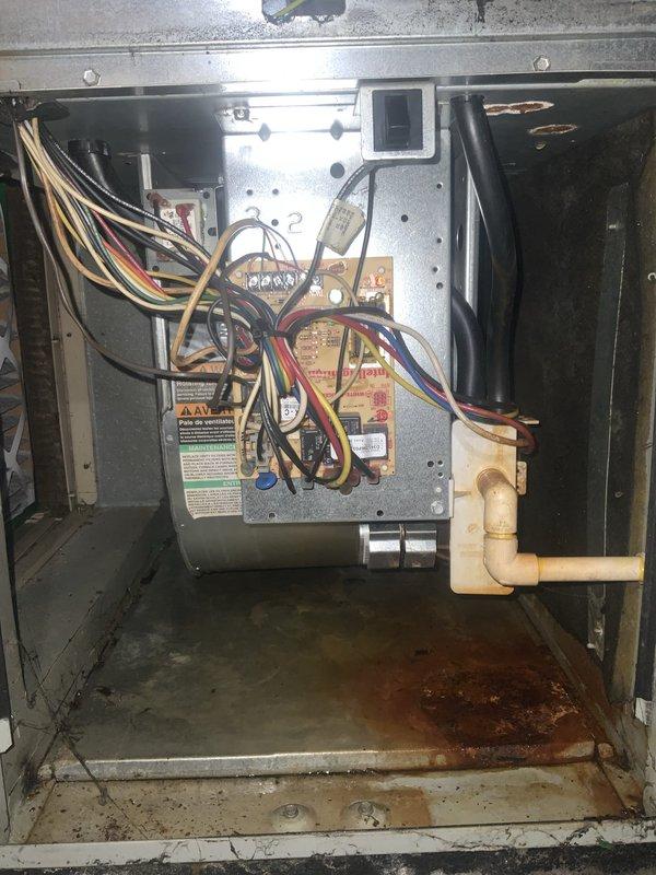 Responded to a no-cool call on a 10+ year old residential air conditioning system experiencing refrigerant line frosting while still maintaining cooling capability. Upon arrival, performed comprehensive system inspection revealing significant moisture damage and rust accumulation in the indoor air handler base pan, indicating prolonged exposure to condensate and possible drainage issues. Outdoor condensing unit showed signs of extended service life with dirt accumulation, aged wiring connections, and general wear throughout the cabinet.

Conducted complete system tune-up as requested, including cleaning condenser coils, inspecting all electrical connections and components, and checking capacitor values. Evaluated refrigerant charge and system pressures to address the frosting condition on refrigerant lines. Examined airflow at indoor unit, checking for restrictions that could contribute to evaporator coil icing. Inspected condensate drainage system due to evidence of water intrusion in