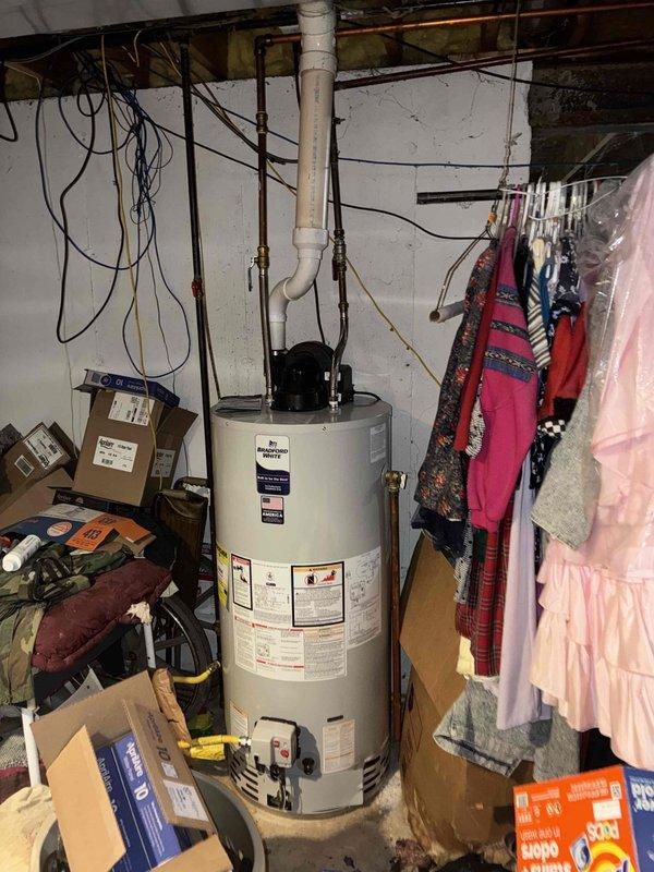 Conducted on-site evaluation for HVAC system replacement at residential property. Assessed existing exterior air conditioning condenser unit and documented current equipment configuration including standby Generac generator, electrical connections, and meter placement. Photographed basement utility area to evaluate water heater and existing mechanical systems for compatibility with proposed HVAC replacement equipment.