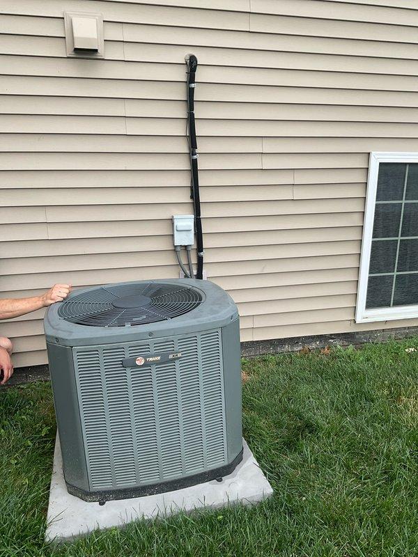 Responded to service call for damaged air conditioning system. Upon inspection of outdoor Trane condensing unit, confirmed that a cooking utensil had fallen into the equipment, causing compressor damage and complete refrigerant loss. Documented equipment condition with photographs showing the outdoor unit on concrete pad and associated indoor furnace system in basement utility area. Provided estimate for full AC system replacement due to extent of compressor damage and refrigerant leak.