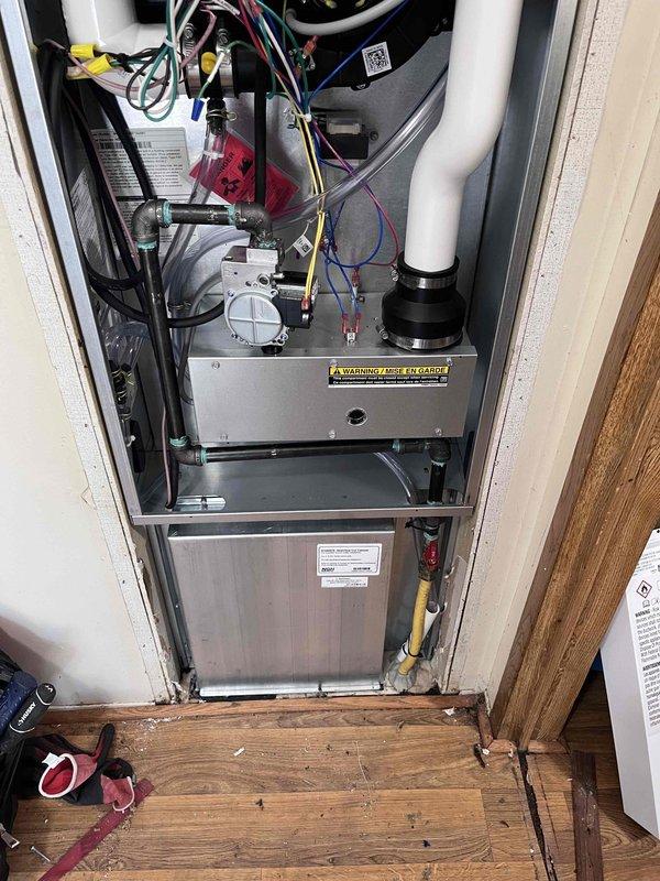 Completed full HVAC system installation including a 60,000 BTU gas furnace and 2.5-ton air conditioning condenser unit. The outdoor condenser was positioned on a concrete pad in the yard with proper clearances from the building structure. All refrigerant lines were connected, evacuated, and charged to manufacturer specifications using manifold gauges. The indoor furnace was installed in the utility closet with appropriate venting through PVC piping, gas supply line connections, and electrical wiring completed per code requirements. System startup procedures were performed, verifying proper operation of both heating and cooling functions. All mechanical connections were secured and tested for leaks, with the system left in full operational status ready for use.