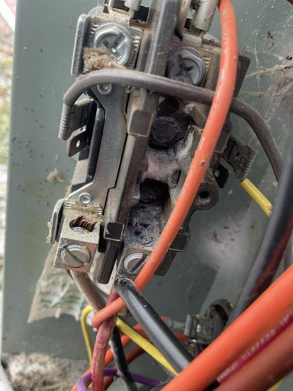 Responded to no cooling call on aging air conditioning system. Upon inspection, discovered severely burned and damaged contactor with extensive heat damage and charring, indicating electrical failure. Removed failed contactor and replaced with new unit. Verified all electrical connections at terminal block were secure and properly torqued. System tested and confirmed operational with normal cooling restored.
