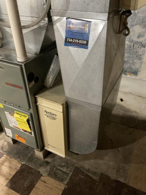 Conducted on-site assessment of existing residential HVAC system consisting of gray Ruud furnace with Aprilaire whole home air cleaning system in basement installation. Documented current equipment configuration including PVC venting, ductwork plenum, and accessory components to provide comprehensive replacement estimate for customer consideration.