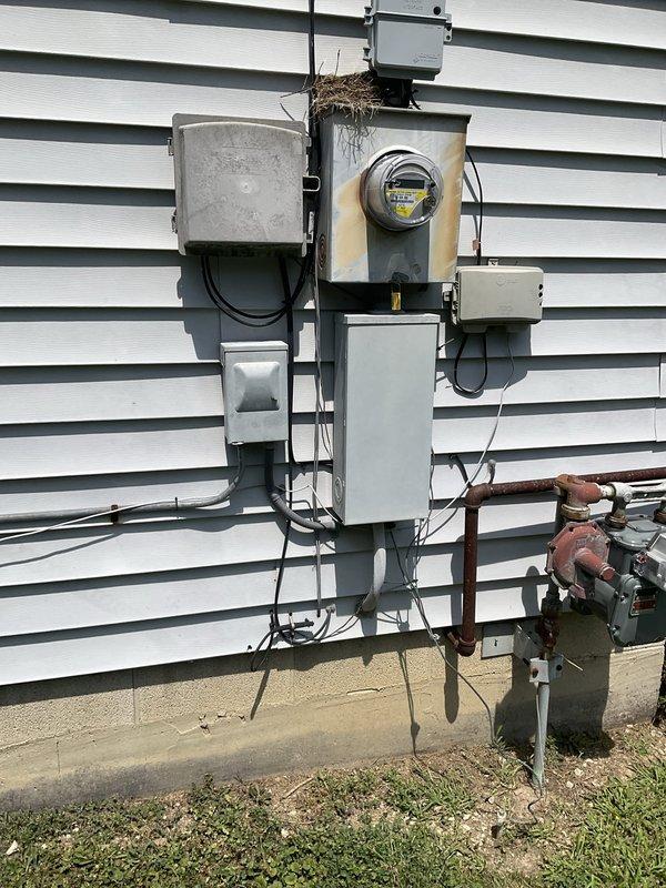 Conducted on-site evaluation of existing rooftop package unit located on side of building for potential replacement. Assessed current RTU air conditioning system and electrical service infrastructure, documenting equipment condition and installation configuration. Photographed existing package unit mounted on wooden platform, noting weathered condition and outdoor exposure wear. Evaluated electrical service entrance components including meter assembly, junction boxes, and conduit routing for compatibility with potential replacement equipment. Discussed option for upgraded packaged unit with integrated heating capability to replace current AC-only system.