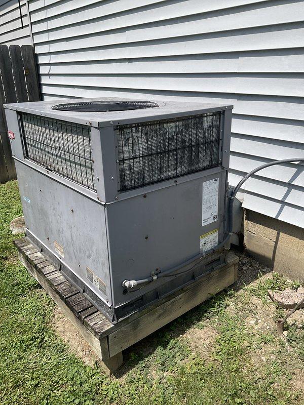 Conducted on-site evaluation of existing rooftop package unit located on side of building for potential replacement. Assessed current RTU air conditioning system and electrical service infrastructure, documenting equipment condition and installation configuration. Photographed existing package unit mounted on wooden platform, noting weathered condition and outdoor exposure wear. Evaluated electrical service entrance components including meter assembly, junction boxes, and conduit routing for compatibility with potential replacement equipment. Discussed option for upgraded packaged unit with integrated heating capability to replace current AC-only system.