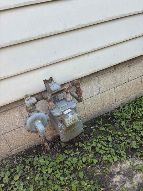 Conducted on-site estimate for complete HVAC system replacement. Documented existing furnace unit located in basement utility area and photographed outdoor gas meter assembly and connections. Recorded model and serial numbers from both furnace and air conditioning components to provide accurate replacement equipment specifications and pricing options for customer consideration.