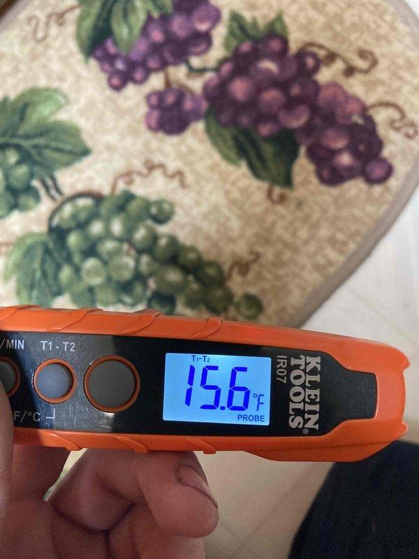 Responded to no cooling complaint on 10+ year old air conditioning system. Upon arrival, found unit running but blowing warm air. Performed electrical diagnostics using clamp meter, measuring 0.82 amps current draw and 0.0 volts at compressor circuit. Measured supply air temperature at 15.6°F, indicating extremely low refrigerant charge or complete loss of refrigerant. Low amp draw and voltage readings consistent with compressor not operating under load due to insufficient refrigerant pressure. System requires refrigerant leak detection, repair, and recharge to restore cooling operation.