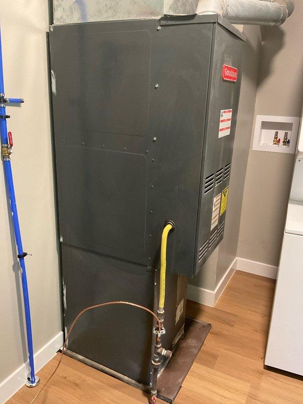 Conducted on-site evaluation of existing HVAC system for equipment replacement estimate. Assessed current natural gas furnace and non-operational air conditioning unit located in indoor mechanical room, documented electrical panel configuration with approximately 20-24 circuit breakers, and photographed existing equipment installation including gas line connections, ductwork configuration, and floor-mounted unit positioning to determine replacement specifications and system requirements.